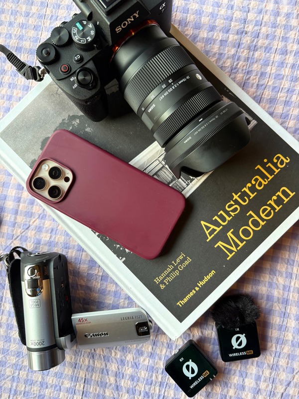 Camera, phone and audio gear laid on an Australia Modern book